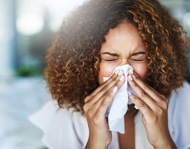 Woman blowing nose