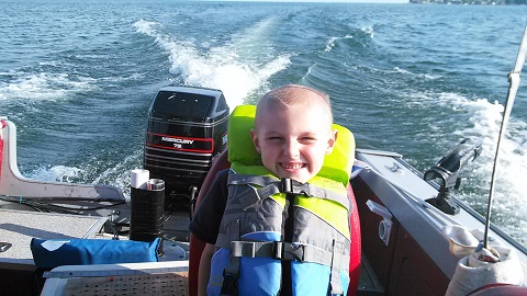 boy in life jacket on boat