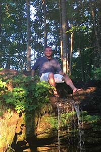 Roberto Novelli sitting above waterfall